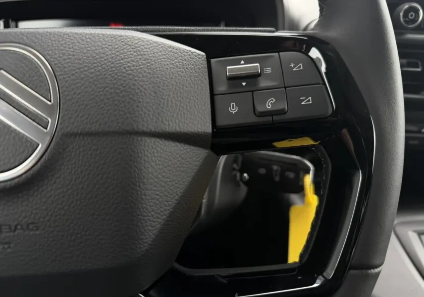 Gros plan sur le volant multifonctions noir du Citroën Berlingo Multispace 2026, avec commandes intégrées.
