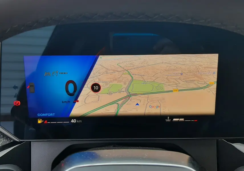 Vue intérieure du tableau de bord numérique de la Renault Clio VI TCe 115ch Techno, affichant la navigation et l'indicateur de vitesse.