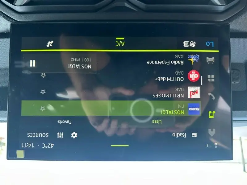 Écran tactile central du Dacia Duster 2025 affichant la liste des radios FM avec interface moderne.