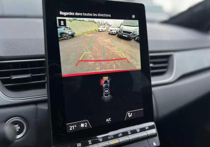 Écran tactile intérieur du Renault Captur 2025 montrant la caméra de recul avec guidage et capteurs de stationnement.