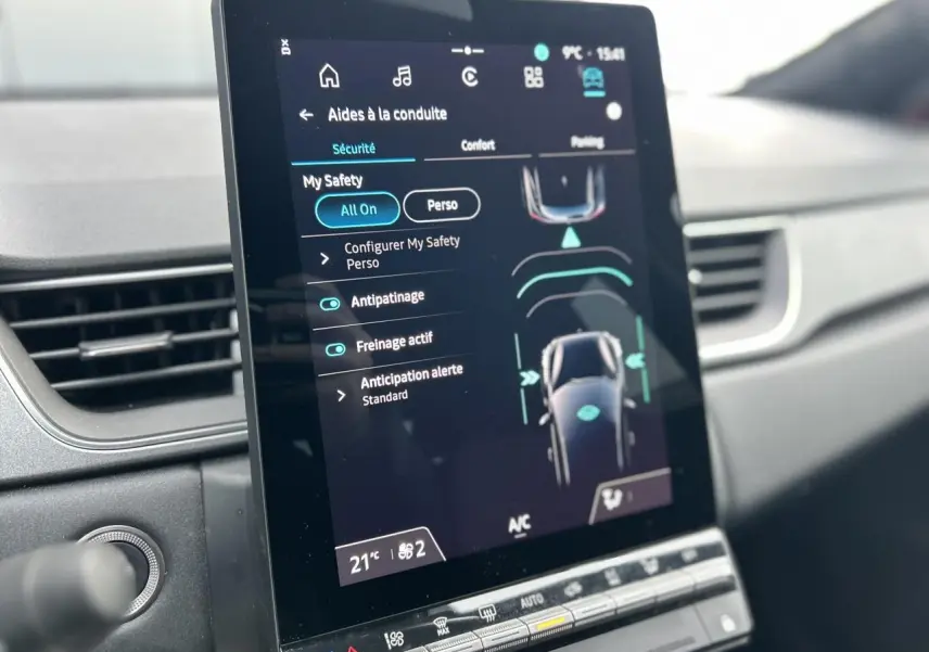 Écran tactile vertical du système OpenR Link 10,4" dans l’habitacle du Renault Captur rouge Flamme, affichant les aides à la conduite.
