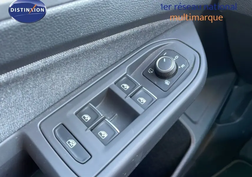 Gros plan sur les commandes de lève-vitres et rétroviseurs côté gauche d’une Volkswagen Golf VIII rouge Roi Metal.