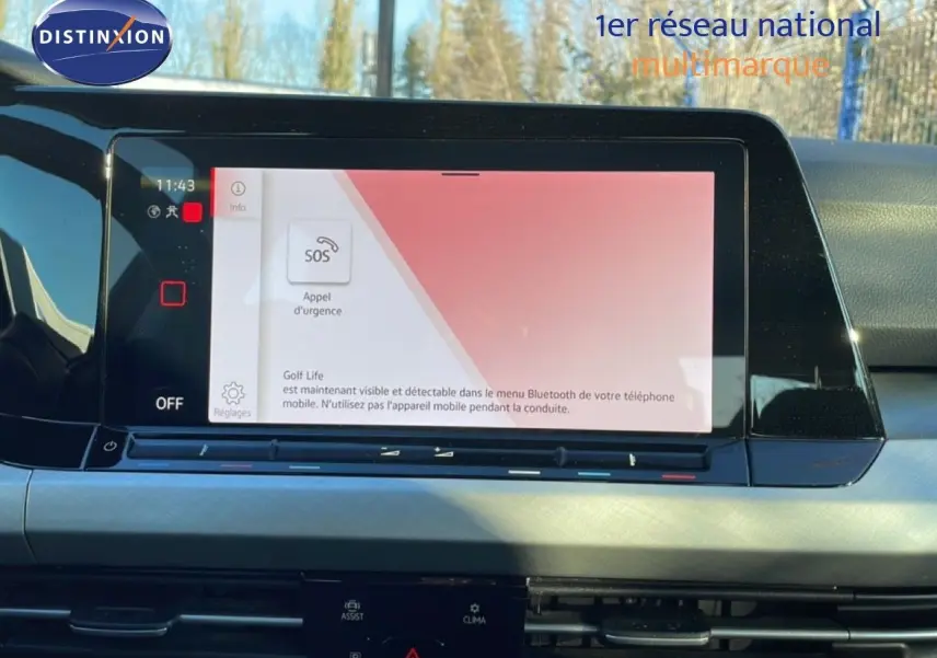 Écran tactile central affichant l'interface d'appel d'urgence dans l'habitacle d'une Volkswagen Golf VIII rouge vue de face.