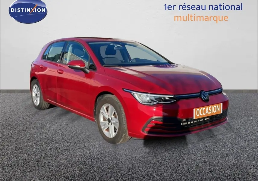 Volkswagen Golf VIII rouge Roi Metal vue 3/4 avant droit sur sol gris, avec plaque occasion visible.