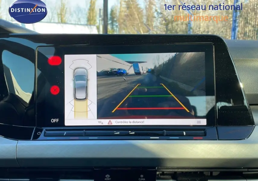 Écran central de la Volkswagen Golf VIII rouge, affichant la caméra de recul avec guidage de trajectoire.