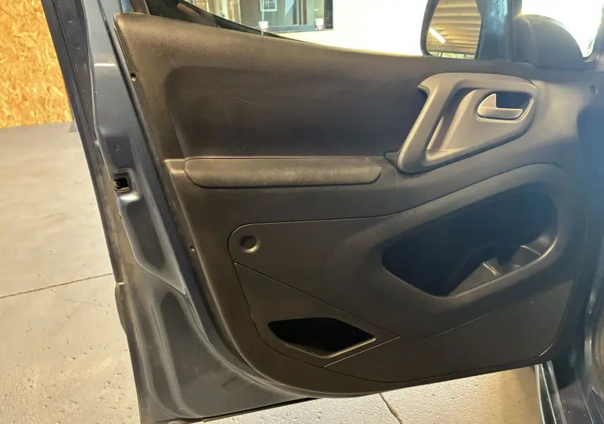 Vue rapprochée de la porte avant gauche noire intérieure du Citroën Berlingo Multispace bleu 2017, version Shine.