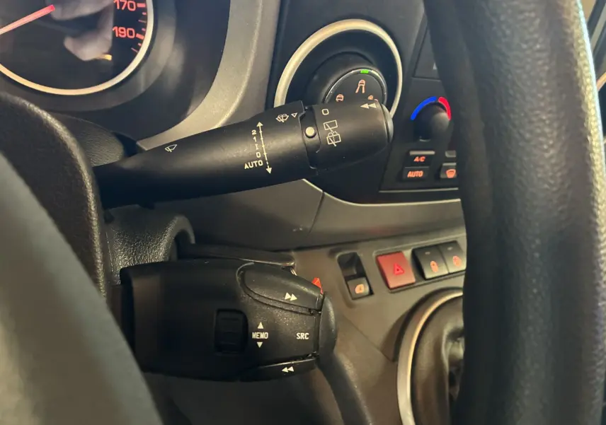 Gros plan sur la colonne de direction et commandes au volant d’un Citroën Berlingo Multispace 2017, intérieur noir.