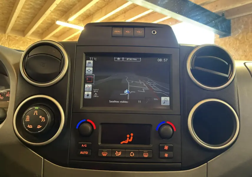 Vue rapprochée du tableau de bord noir du Citroën Berlingo Multispace 2017 avec écran GPS et commandes de climatisation.