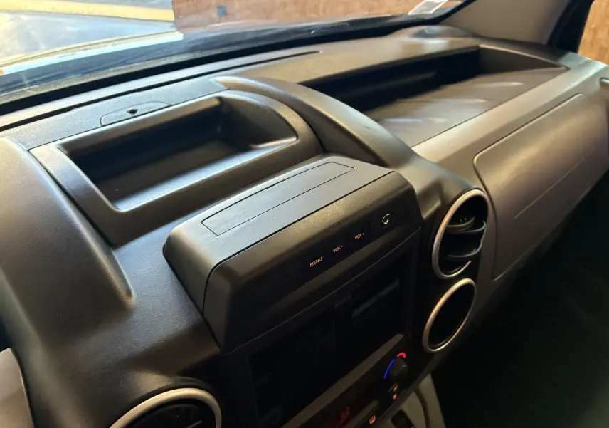 Tableau de bord noir du Citroën Berlingo Multispace 2017, vue rapprochée côté passager avec commandes centrales visibles.