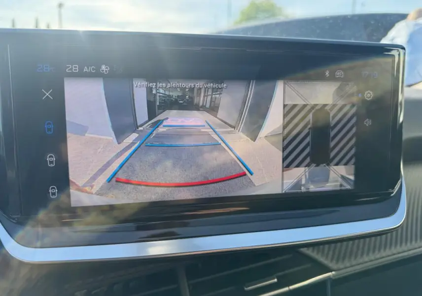 Écran tactile intérieur montrant la caméra de recul avec guidage coloré dans un Peugeot 2008 Hybrid noir.