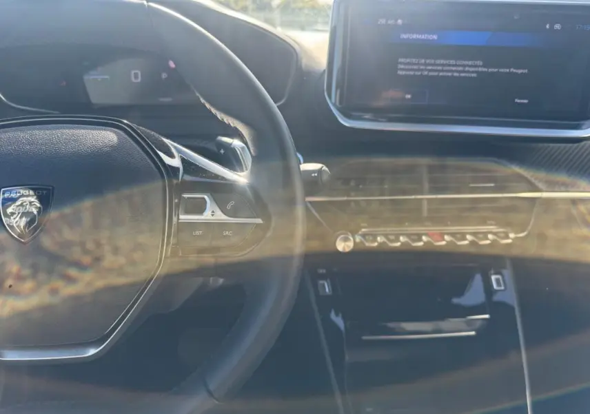 Intérieur du Peugeot 2008 Hybrid 136 Allure 2025 vu du poste de conduite, avec volant multifonction et écran tactile central.