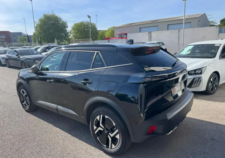 Peugeot 2008 Hybrid noir en 3/4 arrière droit, avec barres de toit, jantes alliage 17 pouces et vitres teintées.