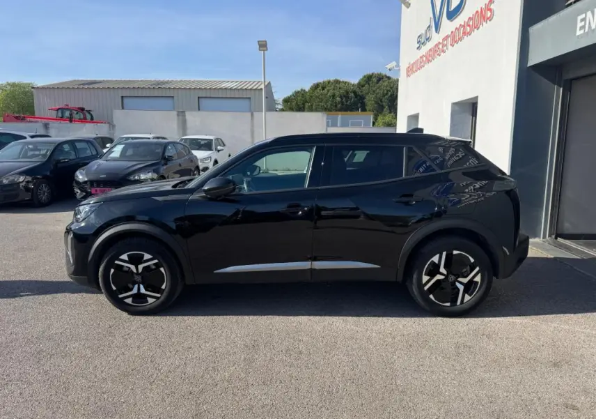 Peugeot 2008 Hybrid noir vue de profil côté gauche, avec jantes alliage 17 pouces et barres de toit visibles.
