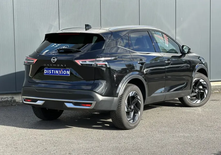 Nissan Qashqai noir nacré vu en 3/4 arrière droit, avec jantes alliage noires et hayon électrique visible.