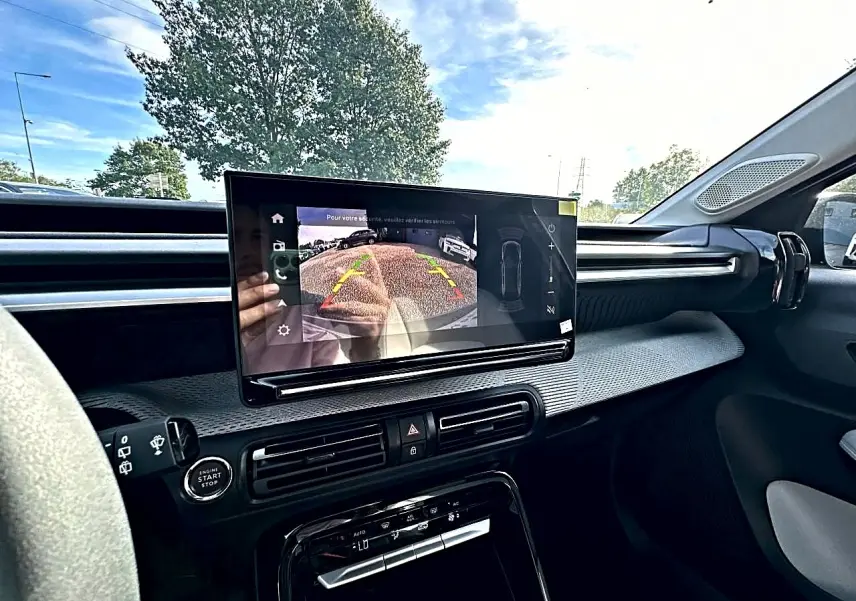 Vue intérieure côté conducteur du tableau de bord du Citroën C3 Aircross noir avec écran tactile affichant la caméra de recul.