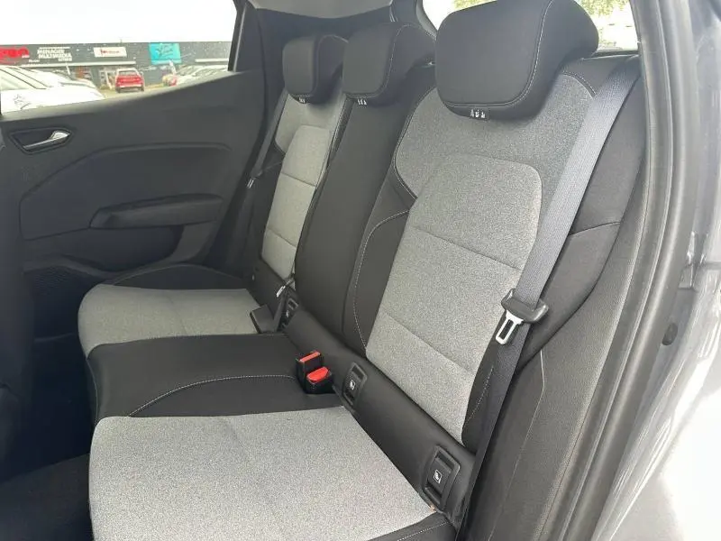 Vue latérale intérieure montrant la banquette arrière gris clair et noir avec ceintures et appuie-têtes de la Renault Clio 2025.