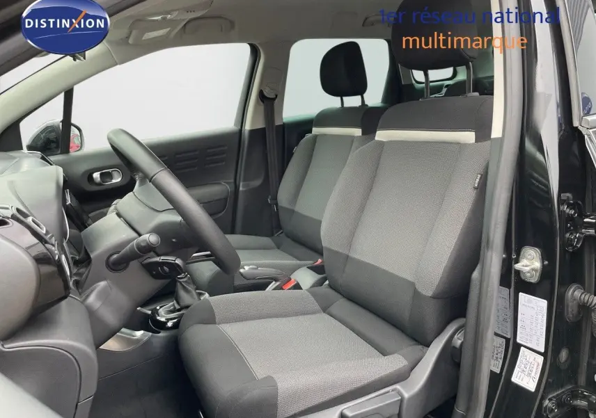 Vue intérieure côté conducteur d'une Citroën C3 Aircross 2023 noir perle métal avec sièges tissu gris et noir.