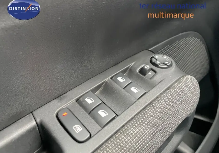 Gros plan sur les commandes des vitres électriques côté conducteur d'une Citroën C3 Aircross 2023 noir perle métal.