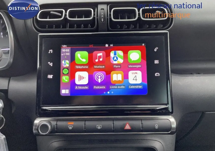Écran tactile central avec interface Apple CarPlay sur tableau de bord noir d'une Citroën C3 Aircross 2023.