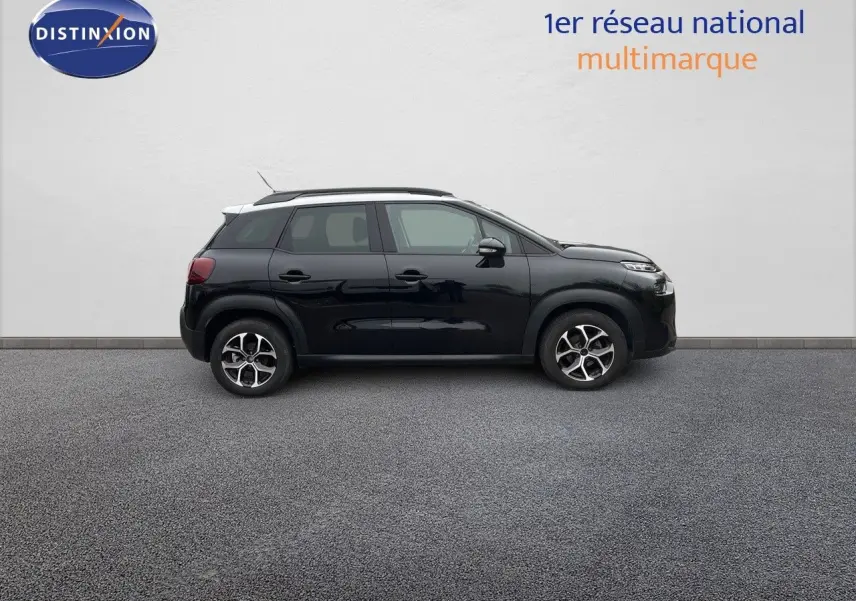 Profil côté gauche d'un Citroën C3 Aircross noir perle métal avec jantes bi-ton et toit blanc sur fond neutre.