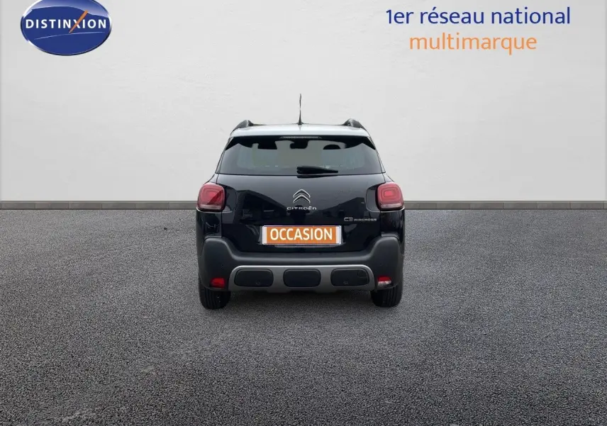 Vue arrière d'un Citroën C3 Aircross noir perle métal avec logo et plaque "OCCASION" visible sur un sol gris.