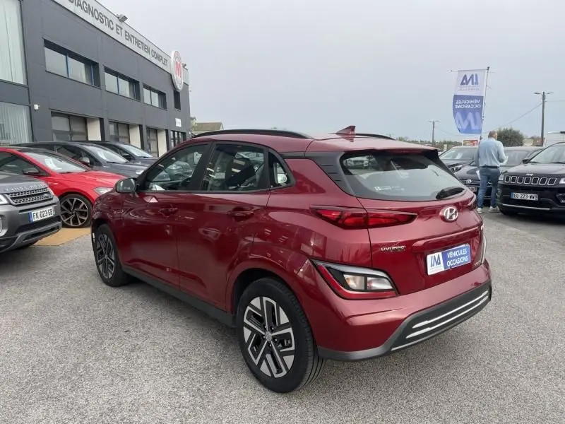 Vue 3/4 arrière droite d'un Hyundai Kona électrique rouge métal 2021, avec feux arrière LED et jantes spécifiques.
