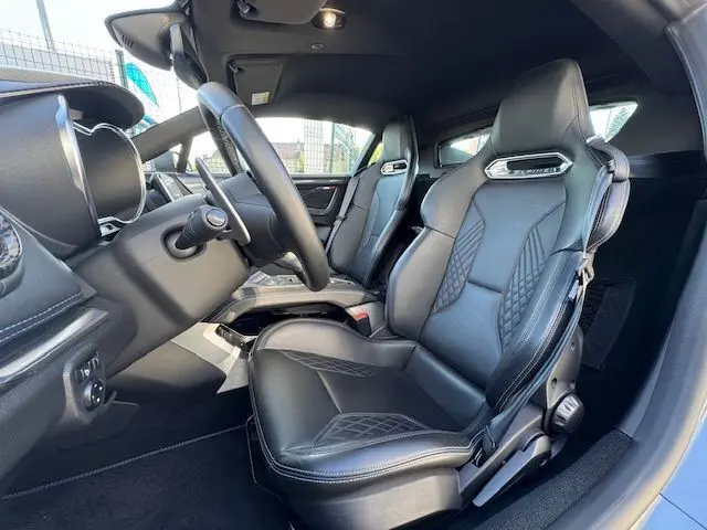 Intérieur côté conducteur de l'Alpine A110 1.8T 252 Légende 2021, sièges cuir noir surpiqué bleu et volant cuir.
