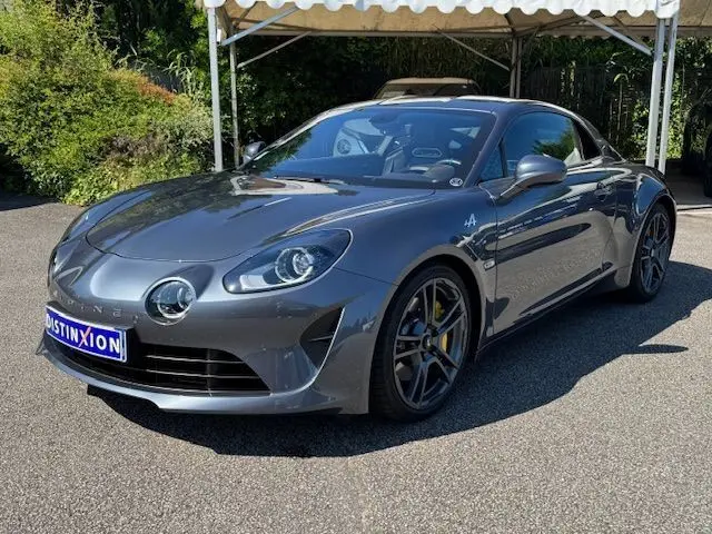 Gros plan sur la roue avant droite d'une Alpine A110 gris acier avec étrier de frein Brembo jaune et logo Alpine sur l'aile.