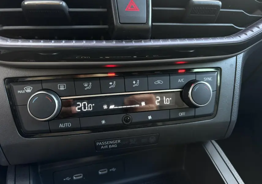 Gros plan sur la commande de climatisation bi-zone noire du tableau de bord de la SEAT Ibiza blanche 2025.