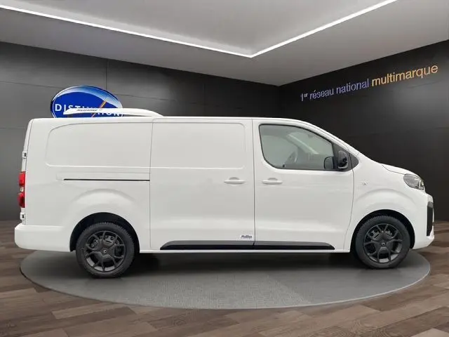 Vue latérale droite d’un Citroën Jumpy XL blanc, fourgon frigorifique avec jantes noires et porte coulissante.