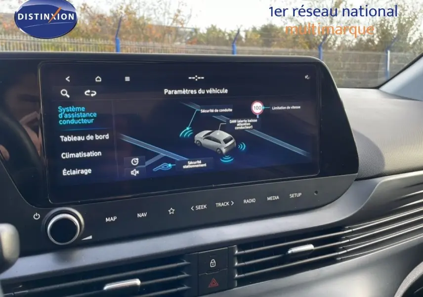Vue intérieure centrée sur l'écran tactile du tableau de bord du Hyundai i20 2025, affichant les paramètres d'assistance conducteur.