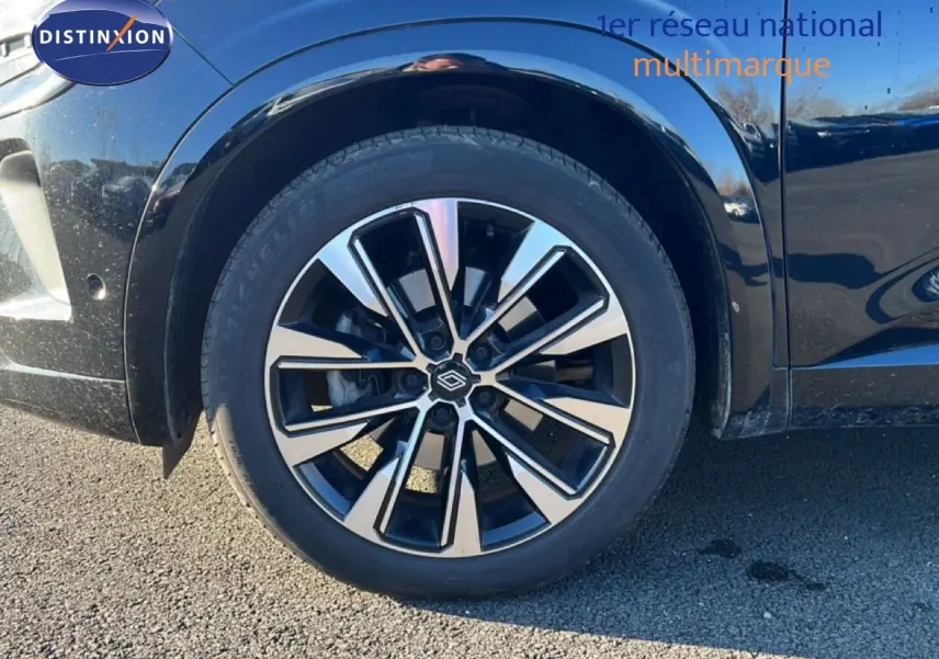 Gros plan sur la roue avant gauche et la jante noire et argent du Renault Austral noir étoile métal.