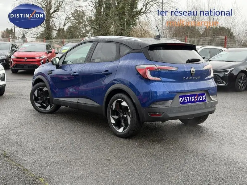 Renault Captur 2025 bleu Iron avec toit noir Etoilé, vue 3/4 arrière droit, jantes noires distinctives.