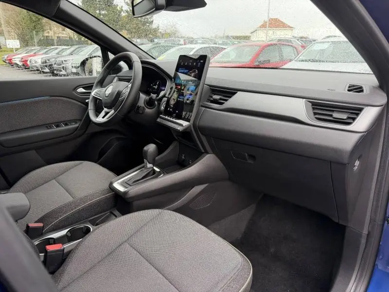 Vue intérieure côté passager du Renault Captur 2025 bleu Iron/Noir Etoilé, avec tableau de bord moderne et écran tactile vertical.