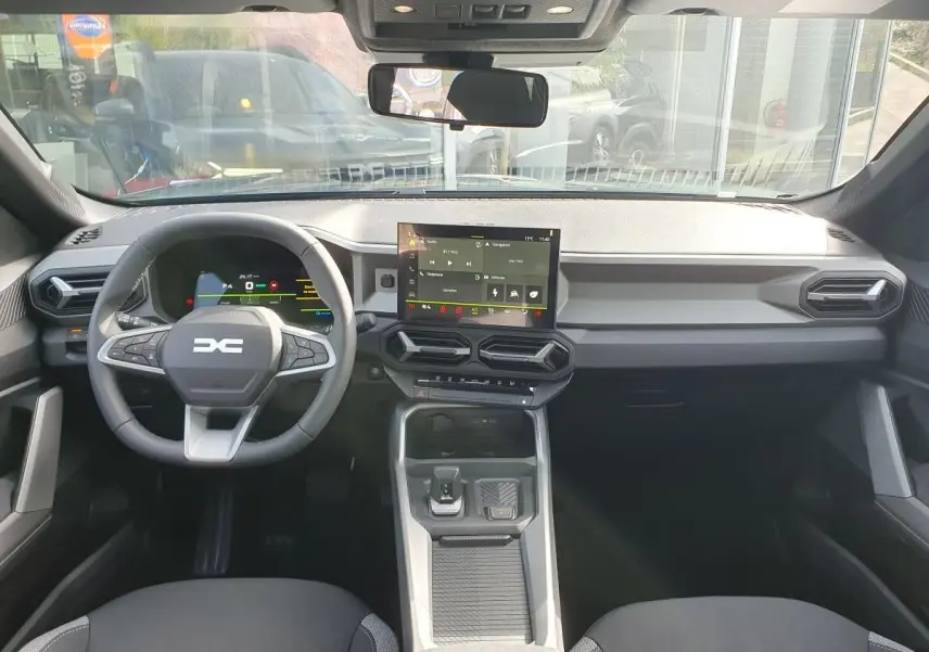 Vue intérieure avant du tableau de bord et volant du Dacia Bigster 2026, avec écran tactile central et design moderne noir.
