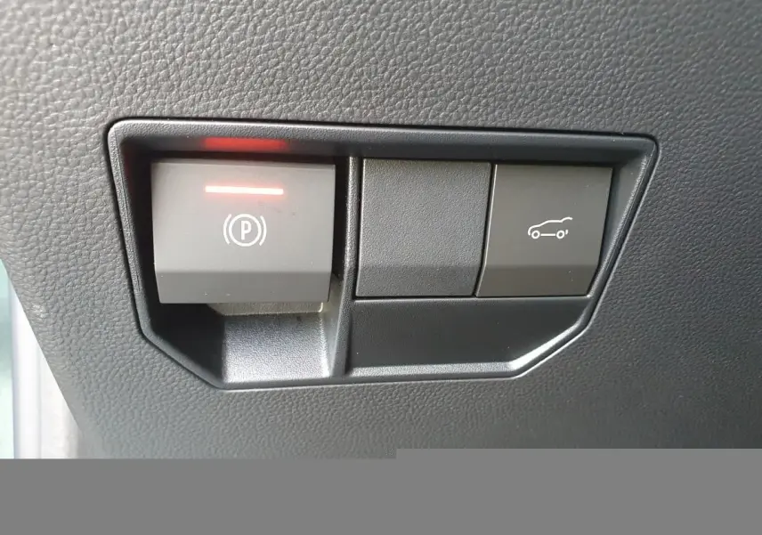 Gros plan sur les boutons de frein de parking électrique et ouverture du coffre du Dacia Bigster, intérieur noir.