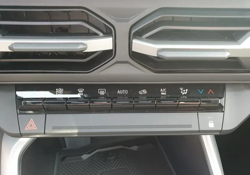 Vue rapprochée du tableau de bord du Dacia Bigster 2026, montrant les commandes de climatisation et ventilation.