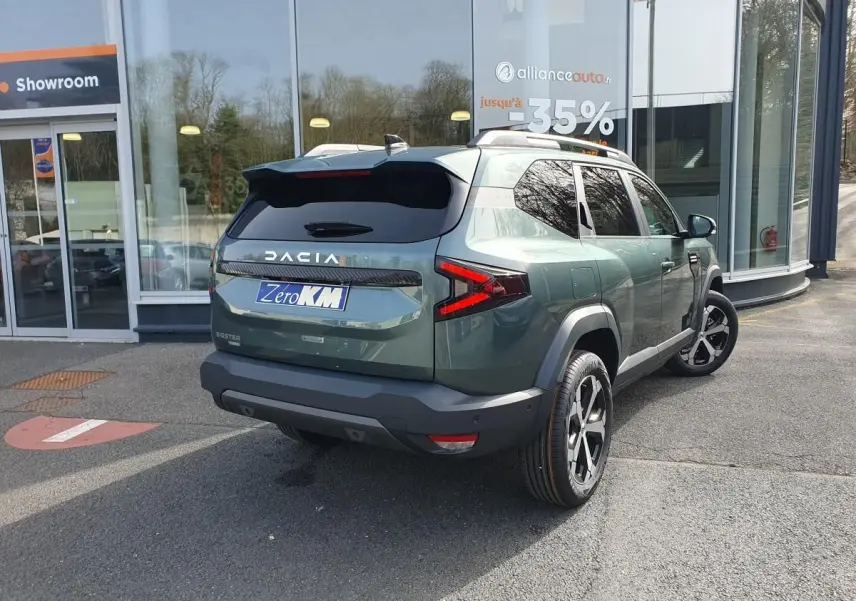 Vue 3/4 arrière droite du Dacia Bigster vert cèdre avec jantes alliage 18” et toit panoramique visible.