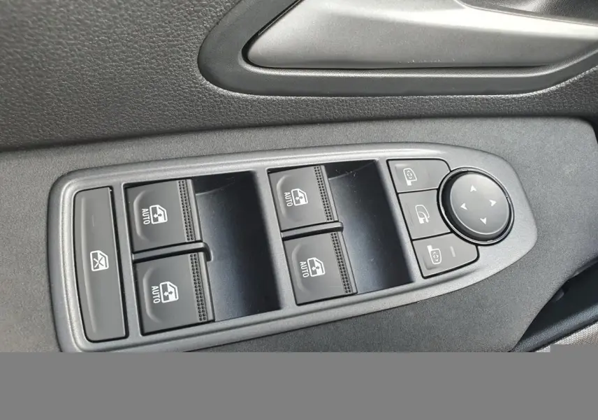 Gros plan sur les commandes des vitres électriques et rétroviseurs du côté conducteur dans un DACIA BIGSTER 2026.