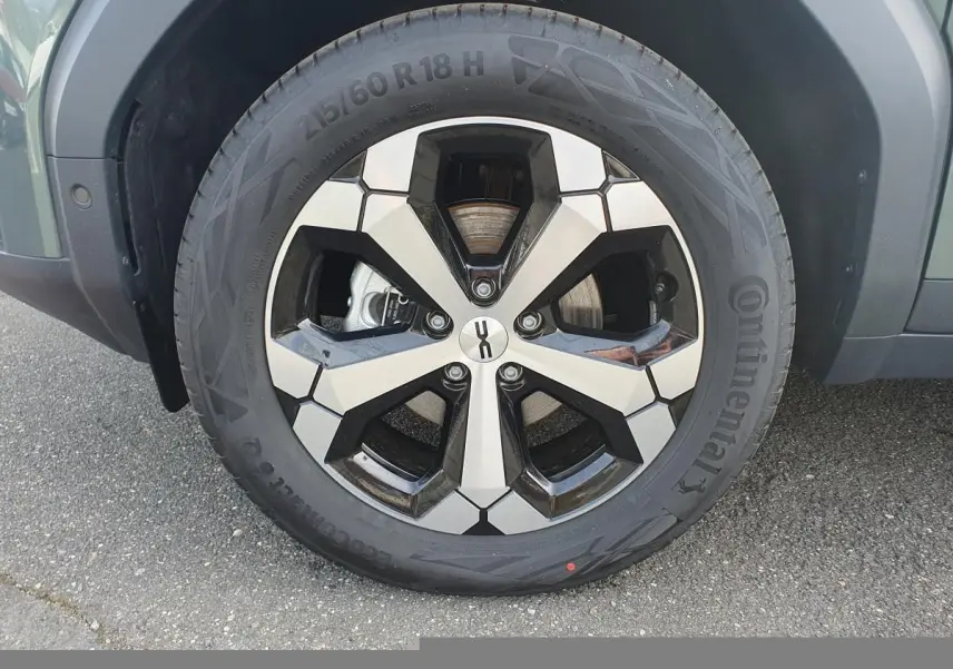 Gros plan sur la jante alliage 18” diamantée Tagasan du Dacia Bigster vert cèdre, avec pneu Continental visible.