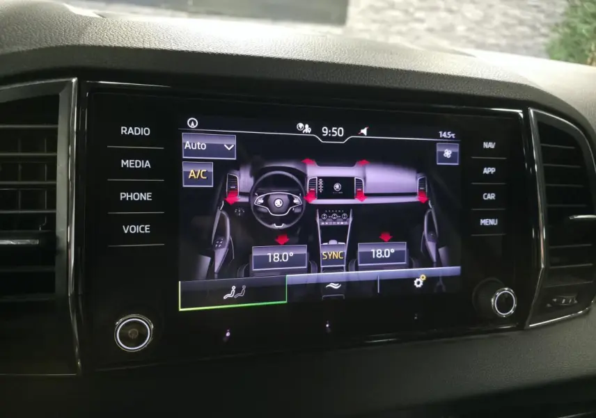 Écran tactile central du Skoda Karoq 2023 affichant la climatisation automatique à 18°C avec commandes digitales.