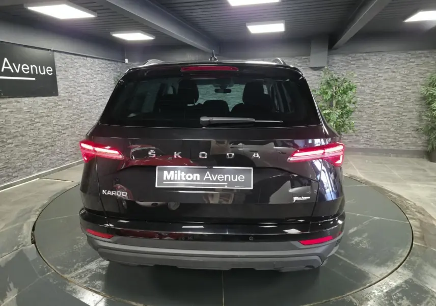 Vue arrière d'un Skoda Karoq noir 2023 avec feux LED allumés dans un showroom intérieur.