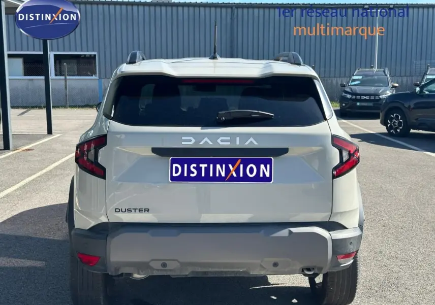 Vue arrière d'un Dacia Duster 2025 couleur Sandstone avec barres de toit et feux arrière LED distinctifs.