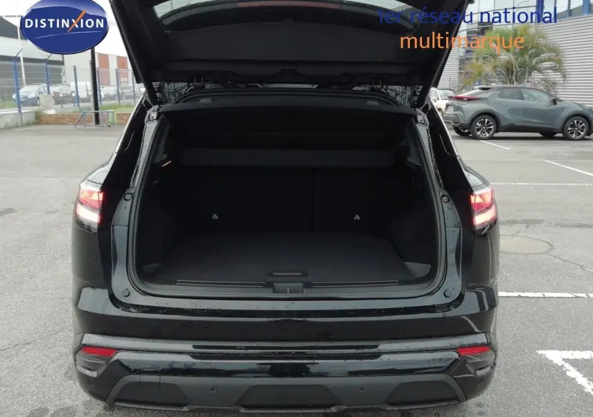 Vue arrière du Renault Austral E-Tech Full Hybrid noir étoile métal avec coffre ouvert, montrant l'espace de chargement vide.