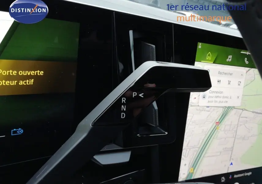 Le levier de vitesses noir du Renault Austral E-Tech, avec écran tactile affichant la navigation en arrière-plan.