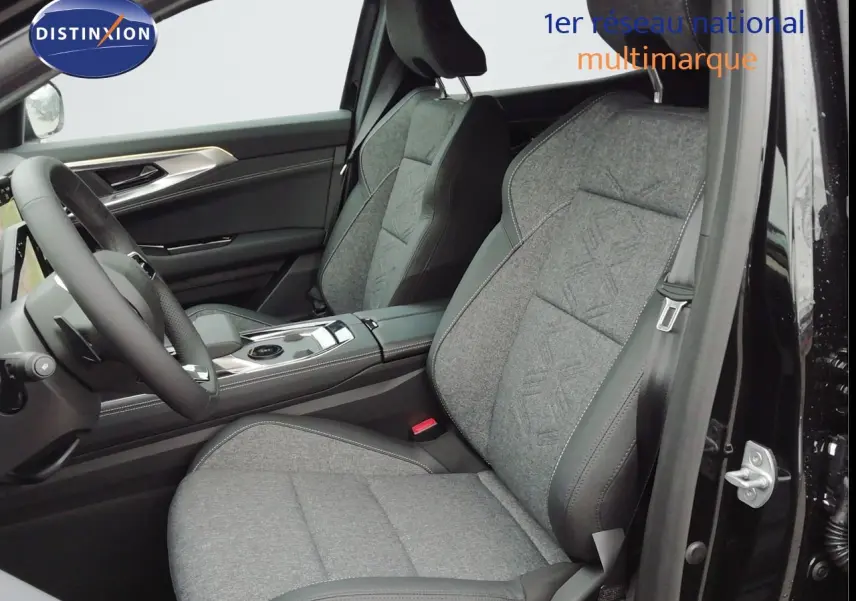 Vue intérieure côté conducteur du Renault Austral 2026 noir étoile métal, sièges tissu gris avec surpiqûres et volant multifonction.