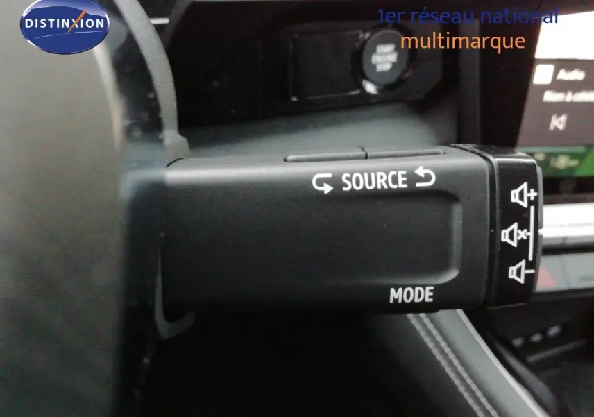 Gros plan sur la commande au volant du Renault Austral noir étoile métal, avec boutons source et mode visibles.