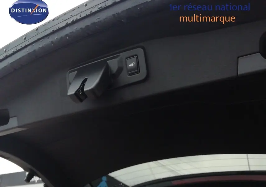 Vue intérieure du hayon ouvert d’un Renault Austral noir étoile métal, montrant la poignée et le bouton d’ouverture électrique.