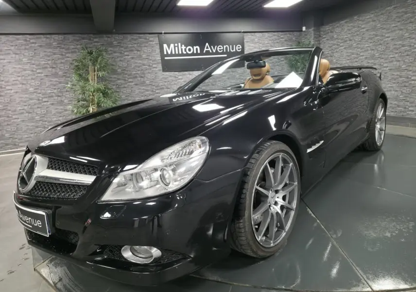 Mercedes SL 500 cabriolet noir vu en 3/4 avant droit avec jantes alliage 19 pouces et intérieur cuir beige.