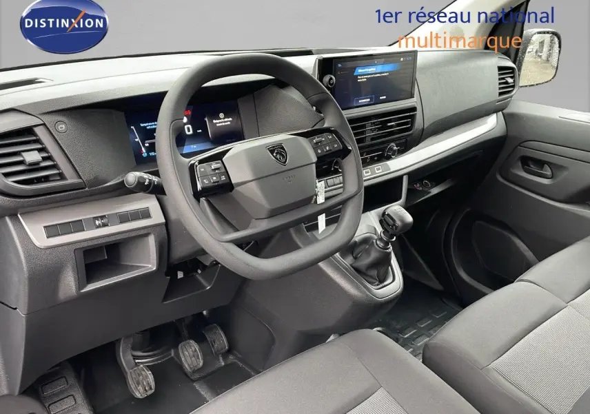 Intérieur du Peugeot Expert Fourgon 2025 vu côté conducteur, tableau de bord noir avec volant multifonction et boîte manuelle.